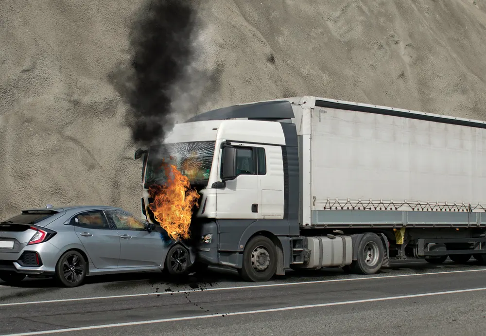 Truck engulfed in flames after colliding with a car on the highway