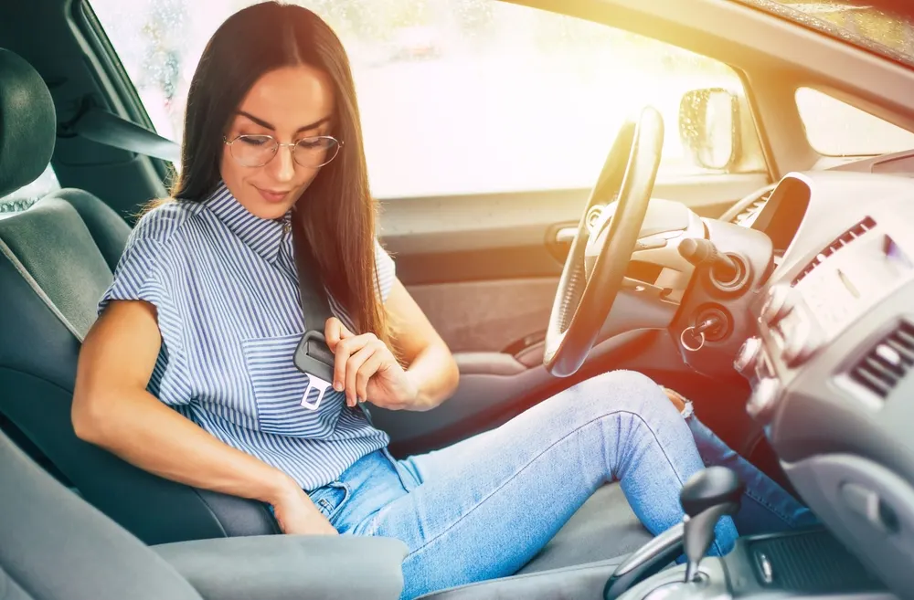 Woman fastening her seatbelt before driving