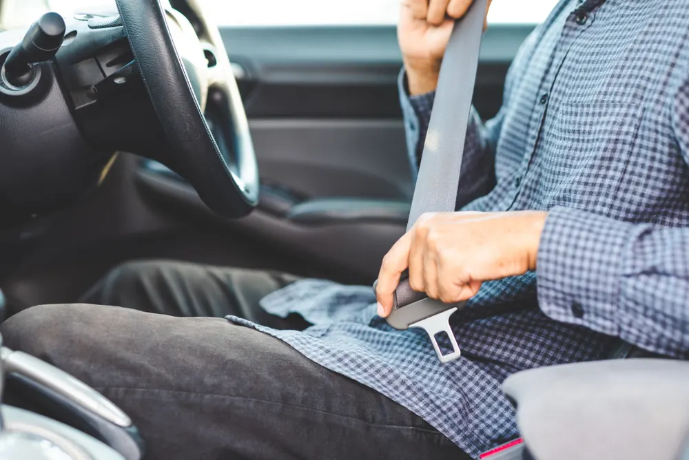 Man fastening his seatbelt in the driver's seat
