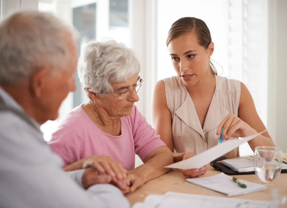 Elderly couple reviewing a settlement document with an advisor